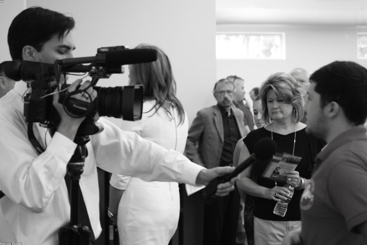 Reportera realizando una entrevista con cámara y micrófono en la calle